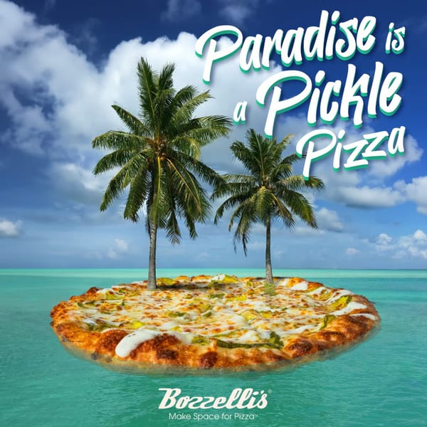 A Bozzelli's pickle pizza floating on turquoise water like an island with two palm trees.
