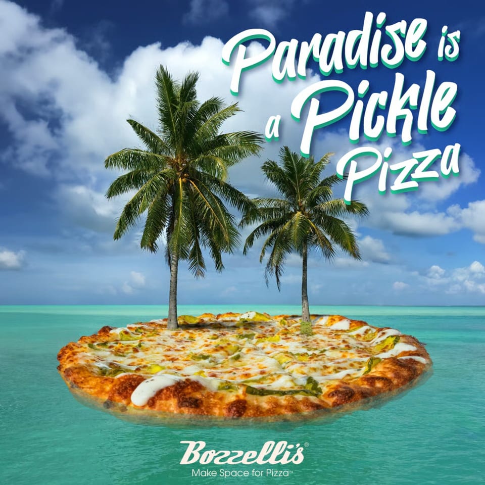 A Bozzelli's pickle pizza floating on turquoise water like an island with two palm trees.