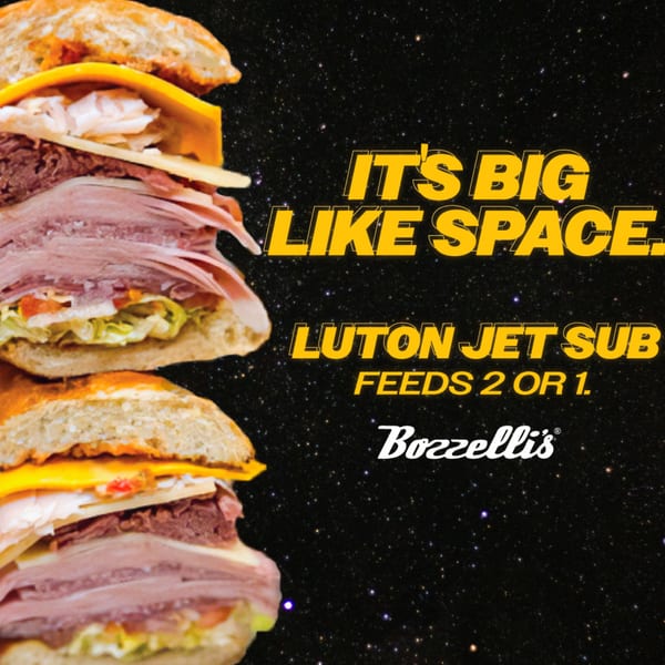 A large Bozzelli's sub sandwich, cut in half, against a starry space background.