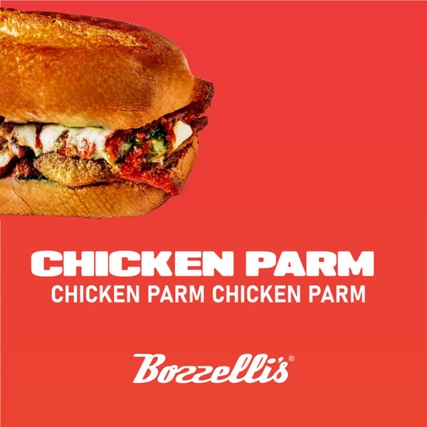 Close-up of a Bozzelli's Chicken Parmigiana sub on a red background.