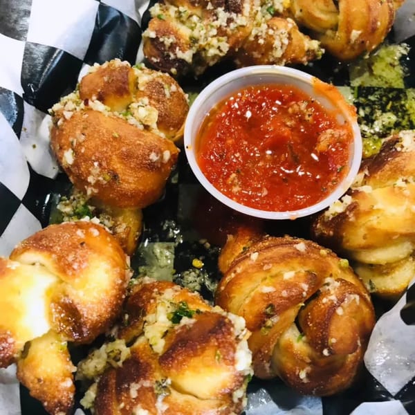 Bozzelli's garlic knots with parmesan and herbs, served with a side of marinara sauce.