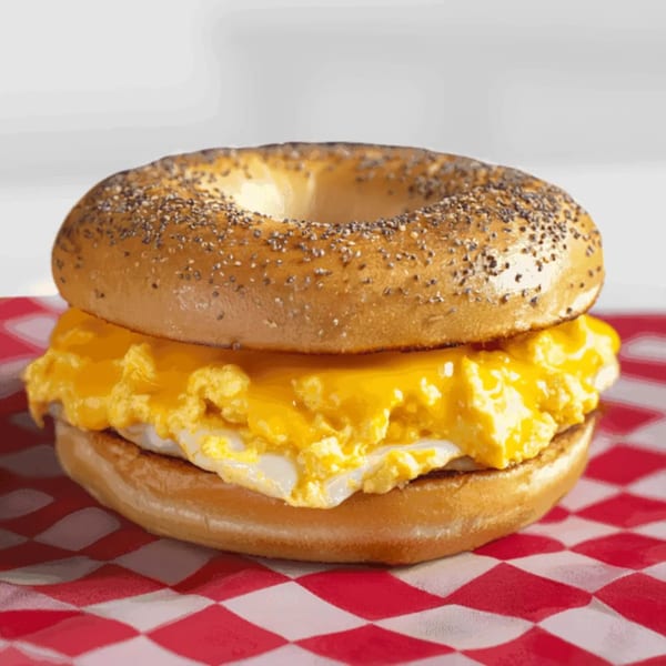 Bozzelli's breakfast bagel with scrambled eggs and melted cheese on a red and white checkered paper.